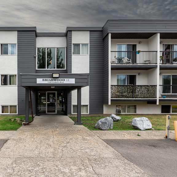 the image shows the front of birchwood 11 apartment complex with a grey and white exterior.