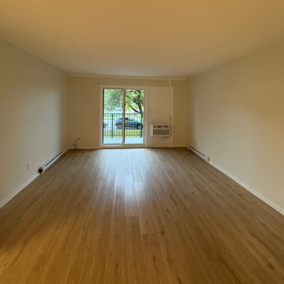 a room with wooden floors and a door leading outside.