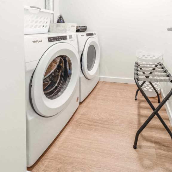 a laundry room with a washer and dryer and a folding chair.