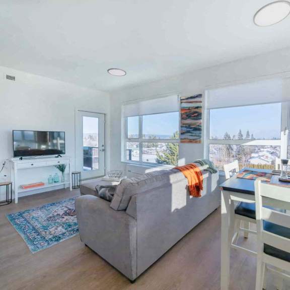 a living room with a grey couch and a white chair.