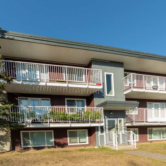 apartment building with balconies and a clear blue sky.