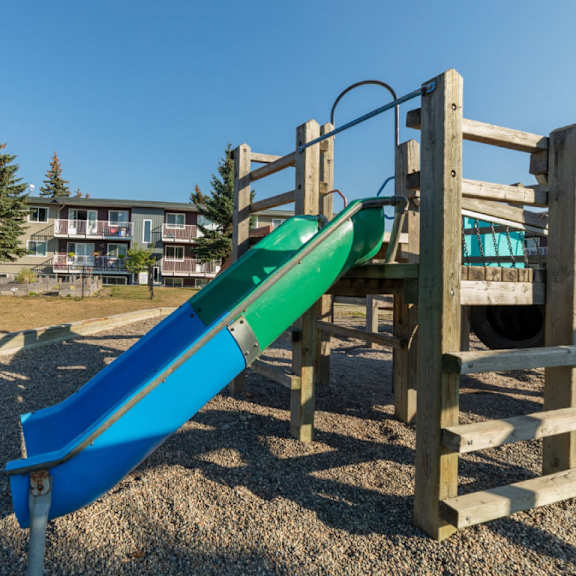 a blue and green slide in a playground.
