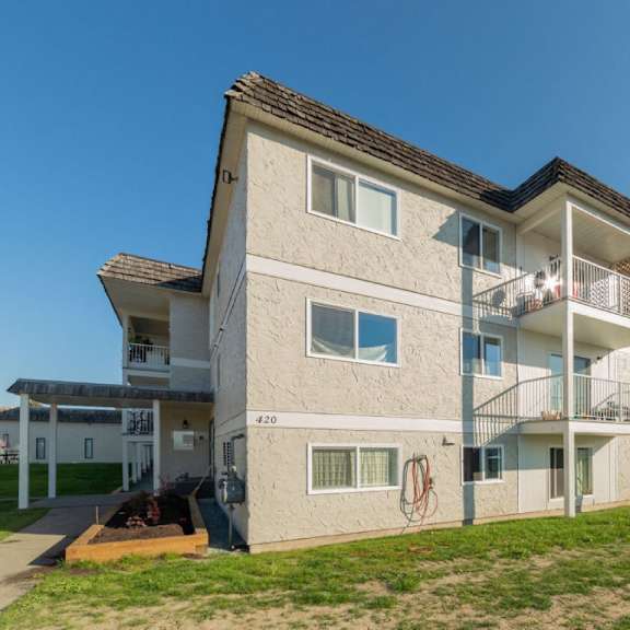 a modern two-story apartment building with a balcony on the second floor.