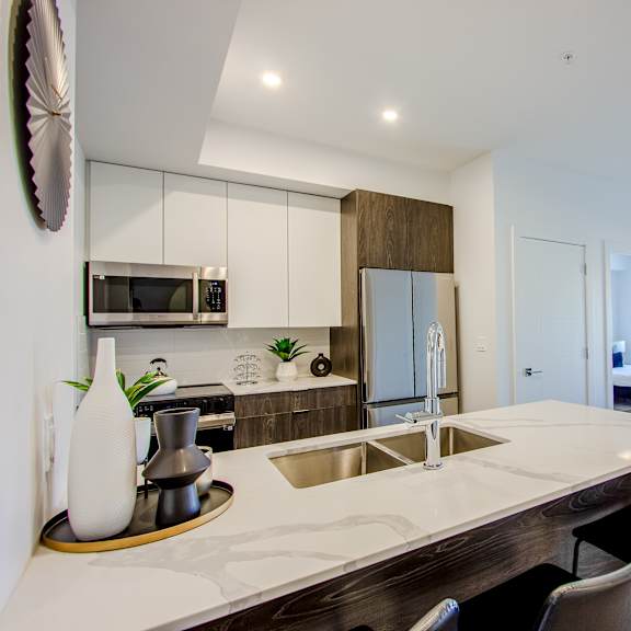 a modern kitchen with a large island and a dining area.