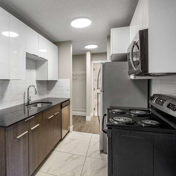 a modern kitchen with dark wood cabinets and a black stove top oven.