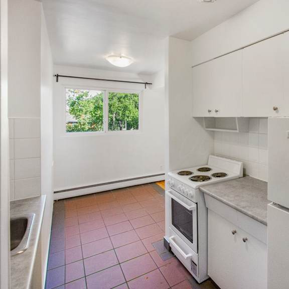 a kitchen with white cabinets and a stove top oven.