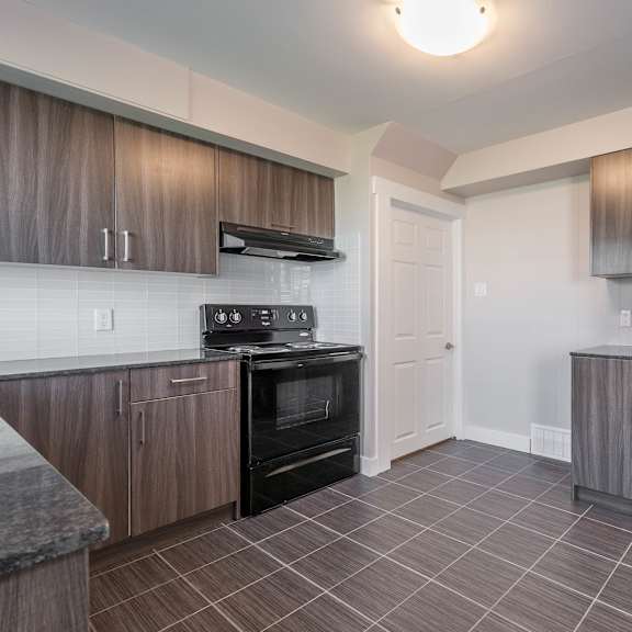 a kitchen with a black refrigerator, stove, and oven.