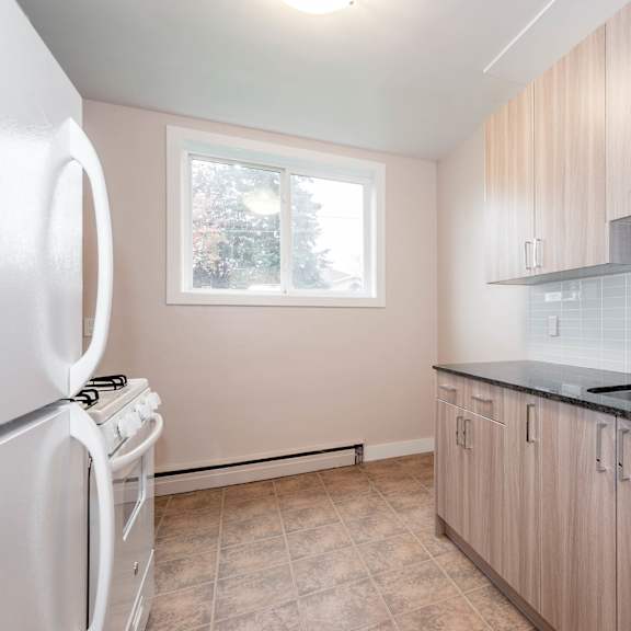 a kitchen with a white refrigerator and wooden cabinets.