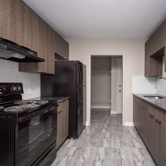 a kitchen with black appliances and wooden cabinets.