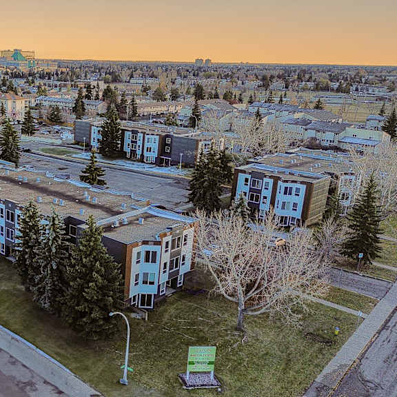 a view of a residential area with apartment buildings and trees.