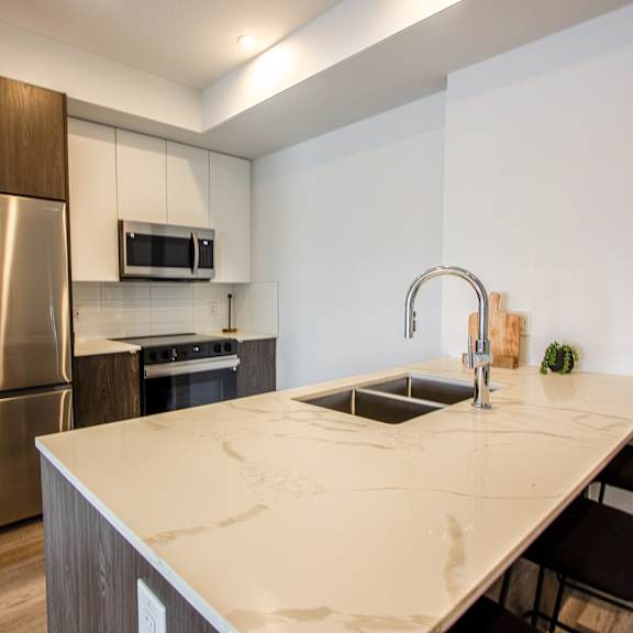 a kitchen with a stainless steel refrigerator and a white countertop.