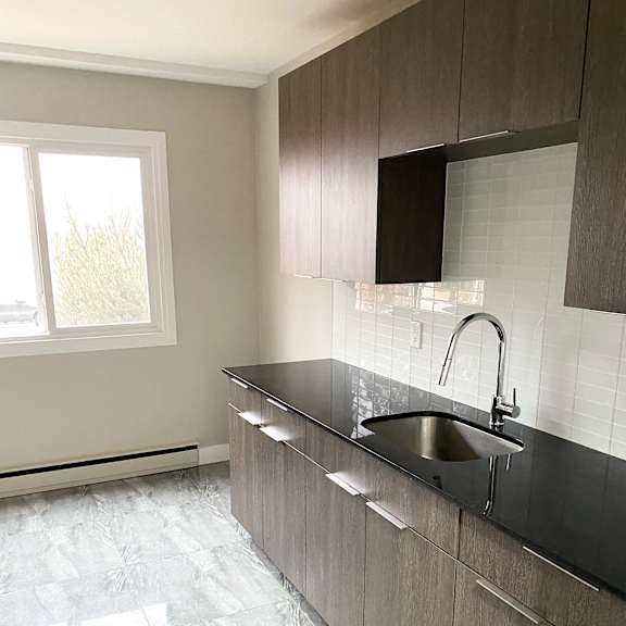 a kitchen with a black counter top and a window.