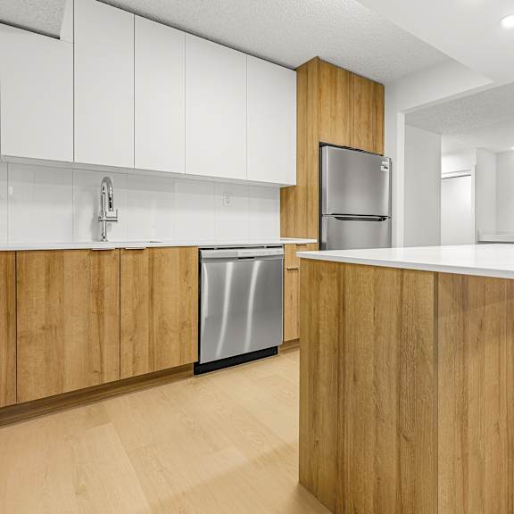 a modern kitchen with wooden cabinets and a stainless steel refrigerator.