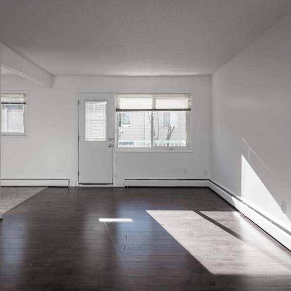 a room with a white door and a window with white blinds.