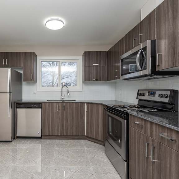 a kitchen with a refrigerator, microwave, and oven.