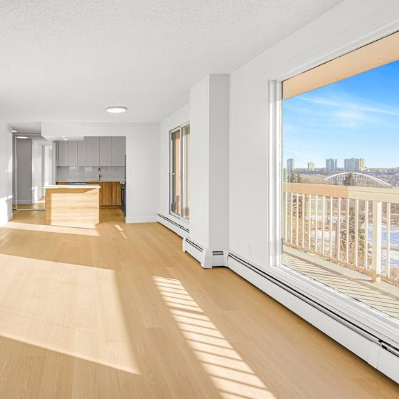a room with wooden floors and a large window overlooking a cityscape.