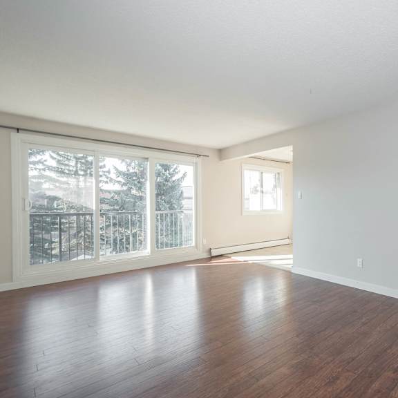 a large empty room with wooden floors and white walls.