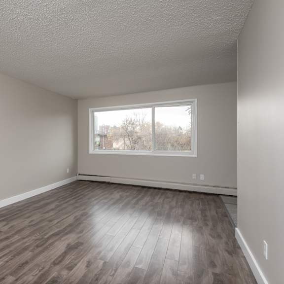 empty room with wooden flooring and a window.