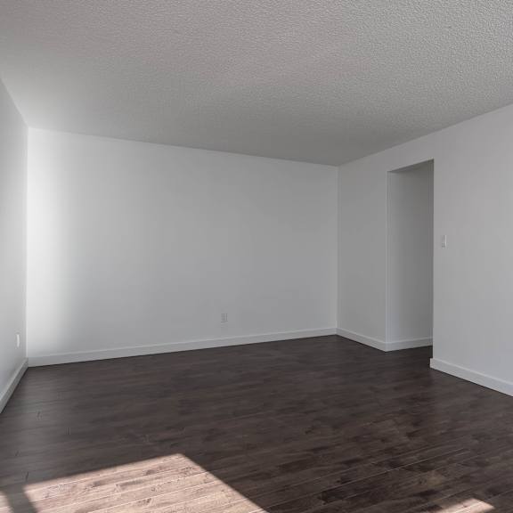 a room with wooden floors and white walls.