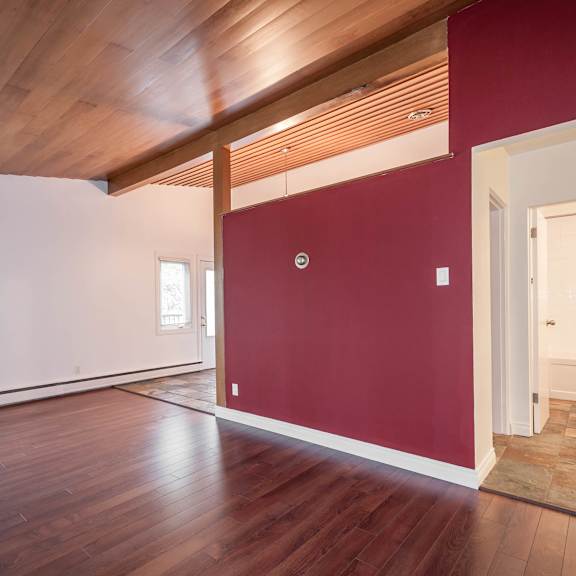 a room with wooden floors and a red wall.