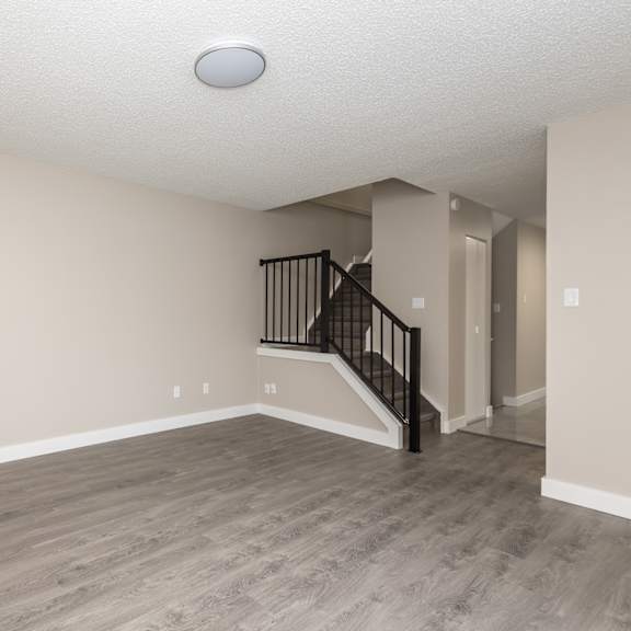 a spacious room with a staircase leading to the upper floor.