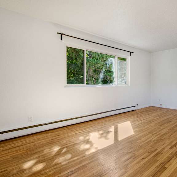 a room with wooden flooring and a window.