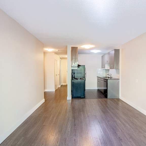 a kitchen area with a refrigerator, sink, and cabinets.