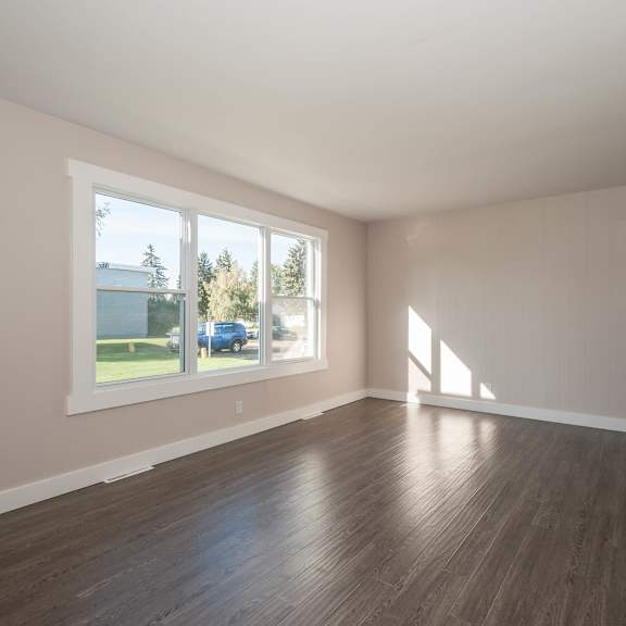 a room with wooden floors and a large window.