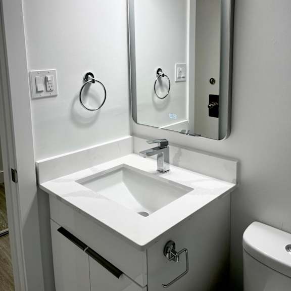 a white bathroom sink with a mirror above it.