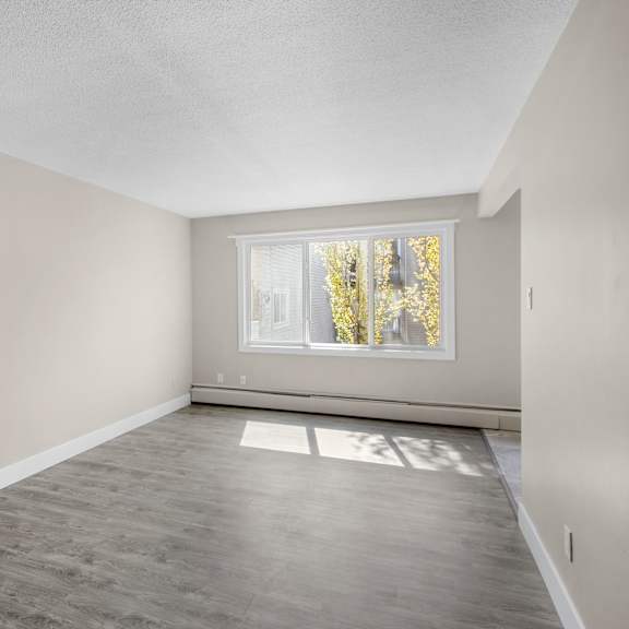 a room with a window and a wooden floor.