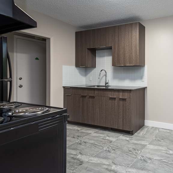 a kitchen with a black stove top oven and a brown cabinet.