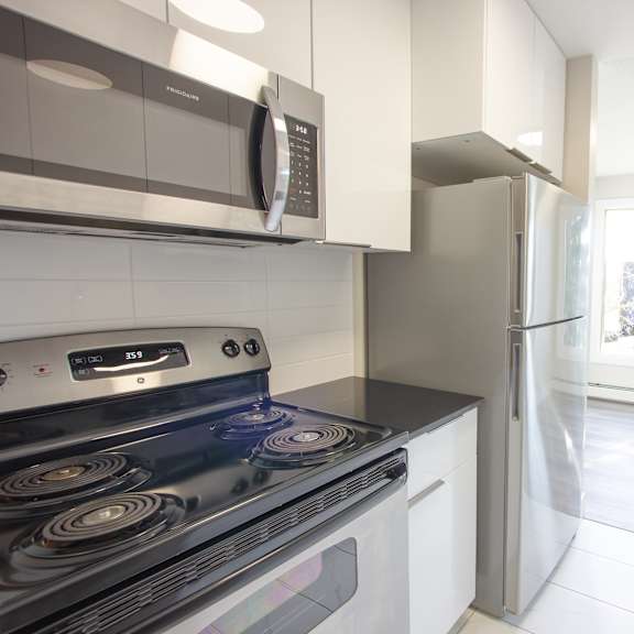a modern kitchen with a stove, microwave, and refrigerator.