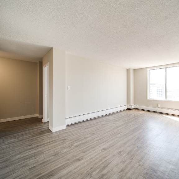 a room with wooden flooring and a window letting in natural light.