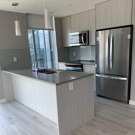 a modern kitchen with a wooden floor and white walls.