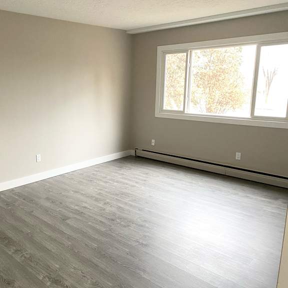 a room with a window and a grey floor.