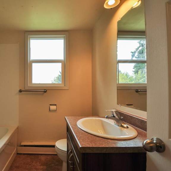 a bathroom with a tub, toilet, and sink.