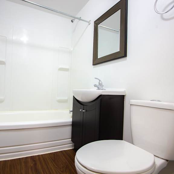 a white toilet sits next to a white bathtub in a bathroom.