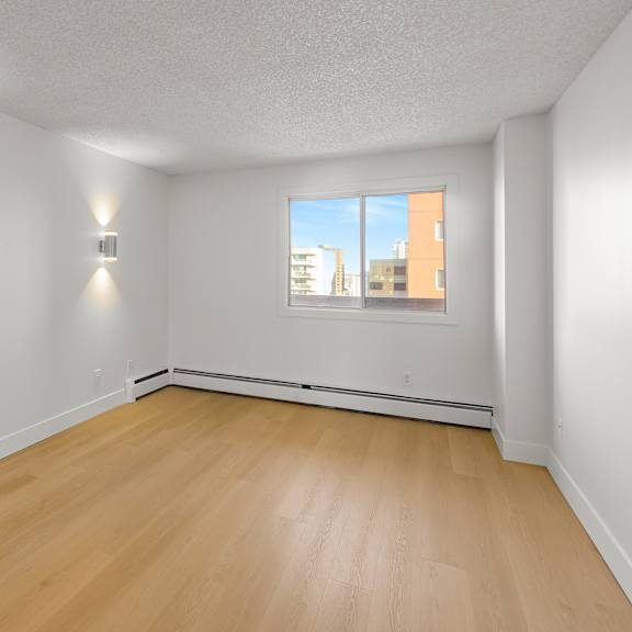 a room with wooden floors and two wall lights.