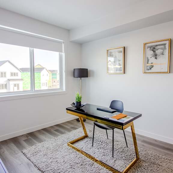 a black and gold table with a plant on it in a room with white walls.