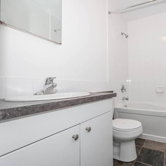 a white bathroom with a sink, toilet, and bathtub.
