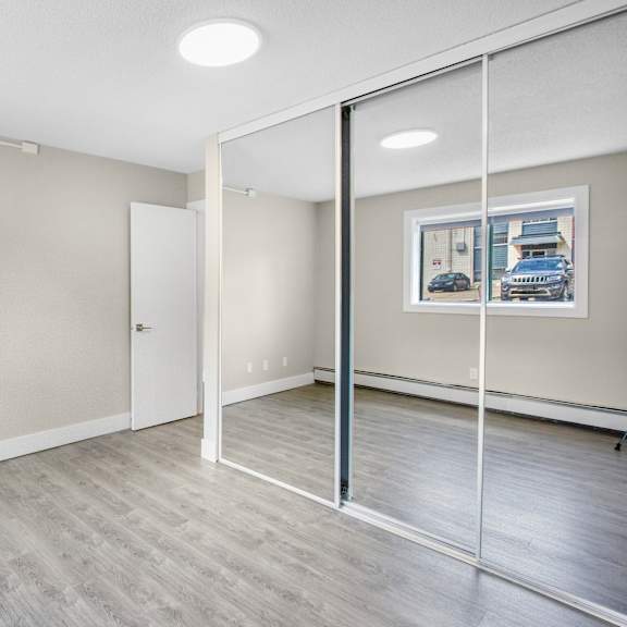 a room with a white door and a picture on the wall.