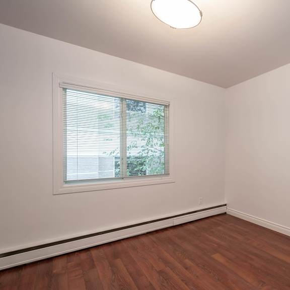 a room with a window and wooden flooring.