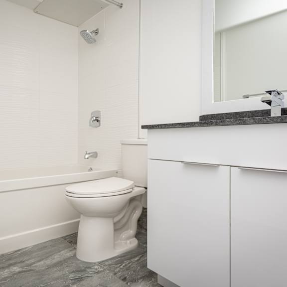 a white toilet sits in a bathroom next to a bathtub.