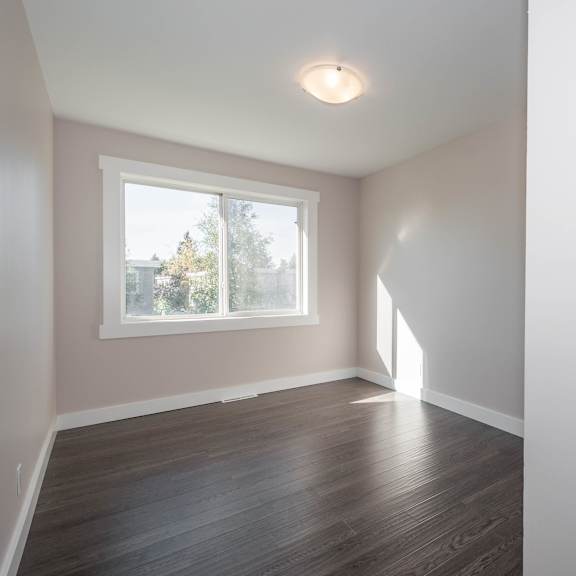 a room with a window and wooden flooring.