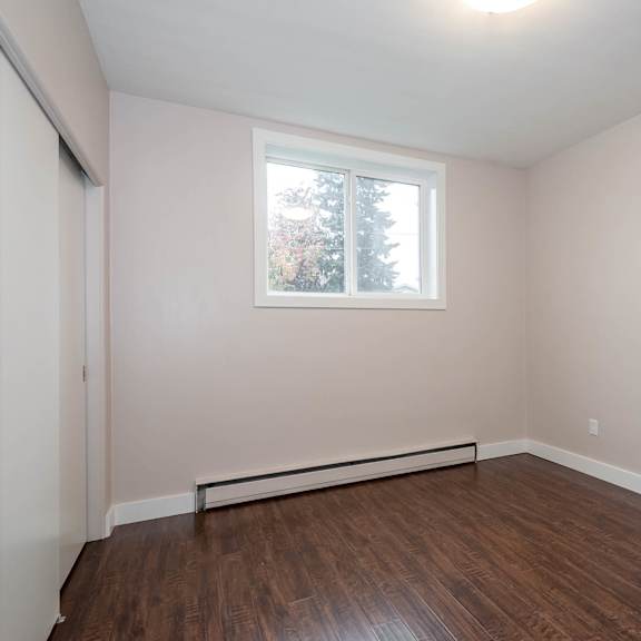 empty room with a window and wooden floor.