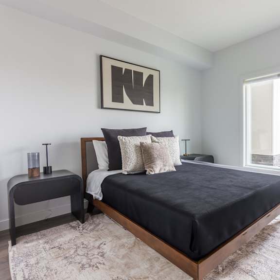 a bedroom with a large bed and a window overlooking a city street.