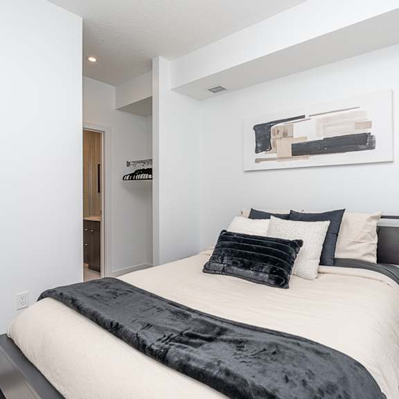 a bedroom with a bed, nightstand, and lamp.