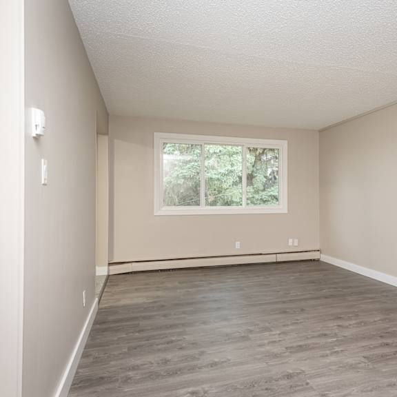 a room with a window and a wooden floor.