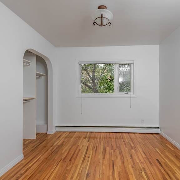 a room with a window and a wooden floor.