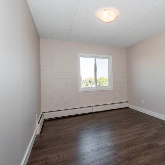 a room with wooden flooring and a window.